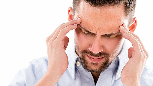 Man holding forehead with headache